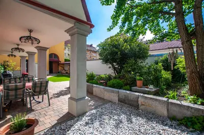 a patio with a table and chairs in a yard at Entire house in the center of Ljubljana - FREE PARKING - Dragon Garden Pavilion Ljubljana in Ljubljana