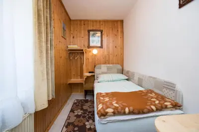 a small room with two beds and a desk at Rooms Pekovec Bohinj in Bohinj