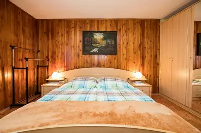 a bedroom with a bed with wooden walls and two lamps at Rooms Pekovec Bohinj in Bohinj