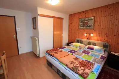a bedroom with a bed in a room with wooden walls at Rooms Pekovec Bohinj in Bohinj