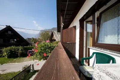 a porch of a house with a bench and a window at Rooms Pekovec Bohinj in Bohinj
