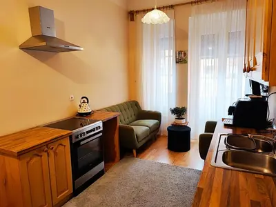 a kitchen and living room with a couch and a stove at Quiet Central in Ljubljana