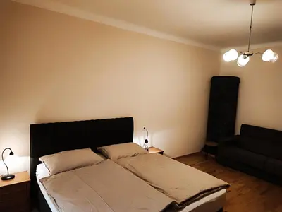 a bedroom with a bed and a black couch at Quiet Central in Ljubljana