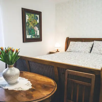 a bedroom with a bed and a table with a vase on it at Apartmaji Aucin - Brda in Kojsko
