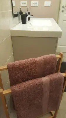 a bathroom with a sink and a towel chair at Apartmaji Aucin - Brda in Kojsko