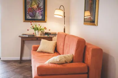 an orange chair sitting in a room with a lamp at Apartmaji Aucin - Brda in Kojsko