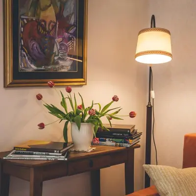 a table with books and a vase with flowers on it at Apartmaji Aucin - Brda in Kojsko