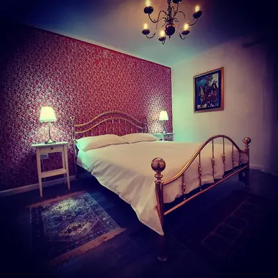 a bedroom with a bed and a red wall at Apartmaji Aucin - Brda in Kojsko