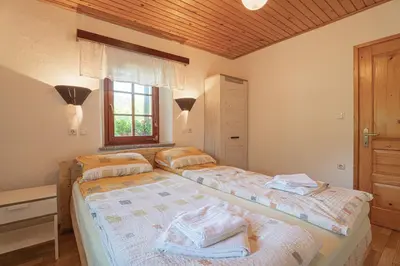 a bedroom with two beds and a window at Vineyard cottage Kolpa Zupančič in Stari Trg ob Kolpi