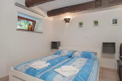 a white bedroom with a bed with towels on it at Vineyard cottage Kolpa Zupančič in Stari Trg ob Kolpi
