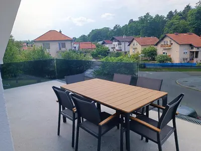 a wooden table and chairs on a patio at Apartma FRIGO in Maribor