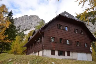 a large wooden house on top of a hill at Erjavčeva mountain hut at Vršič pass in Kranjska Gora