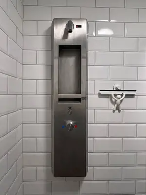 a ticket machine on the wall of a bathroom at Erjavčeva mountain hut at Vršič pass in Kranjska Gora