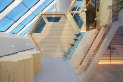 a room with a wooden staircase in a building at Honeybee Hostel - Hiša kranjske čebele in Višnja Gora