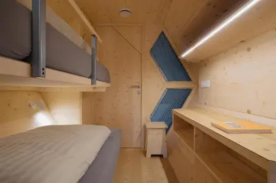 a small room with a bed and a desk at Honeybee Hostel - Hiša kranjske čebele in Višnja Gora