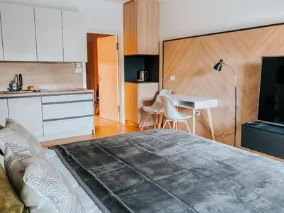 a bedroom with a large bed and a kitchen at Oasis of Energy in Ljubljana