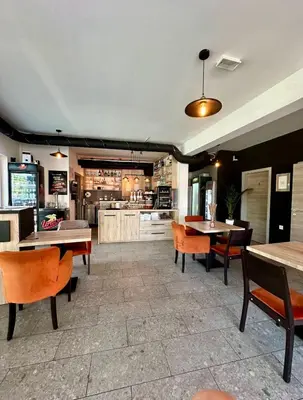 a restaurant with tables and chairs and a kitchen at Oasis of Energy in Ljubljana