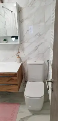 a white bathroom with a toilet and a sink at Apartma Sivi žako in Bohinj