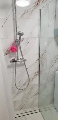 a bathroom with a shower with a glass door at Apartma Sivi žako in Bohinj