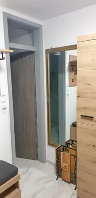 a room with a door and a mirror in a room at Apartma Sivi žako in Bohinj