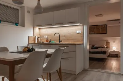 a kitchen and dining room with a table and chairs at Cozy Little Apartments in Ig