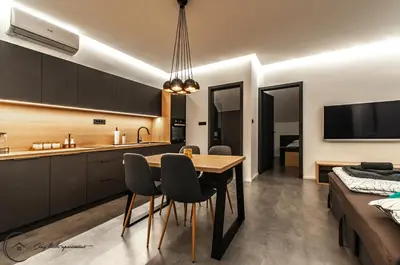 a kitchen and dining room with a table and chairs at Cozy Little Apartments in Ig
