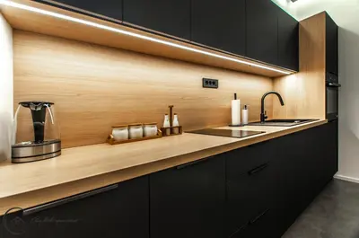 a kitchen with black cabinets and a wooden counter top at Cozy Little Apartments in Ig