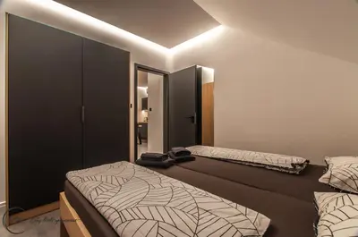 a bedroom with two beds and a light on the ceiling at Cozy Little Apartments in Ig
