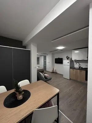 a living room with a table and a kitchen at Apartma Studio Jana in Kranjska Gora