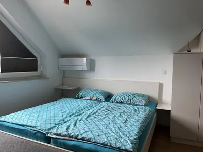 a small bedroom with a bed with a blue comforter at Apartma Ajda 2 , Jezerska cesta 65, Kranj in Kranj