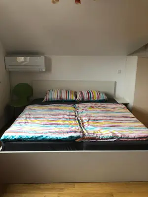 a bed with a colorful blanket on it in a room at Apartma Ajda 2 , Jezerska cesta 65, Kranj in Kranj