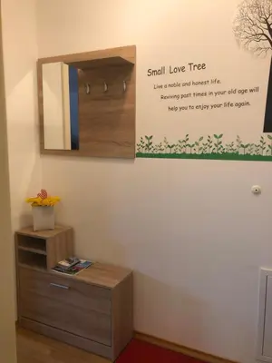 a small love tree sign on a wall next to a mirror at Apartma Ajda 2 , Jezerska cesta 65, Kranj in Kranj