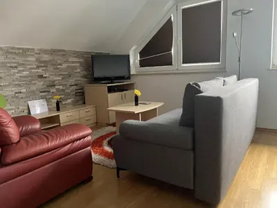 a living room with a couch and a chair at Apartma Ajda 2 , Jezerska cesta 65, Kranj in Kranj