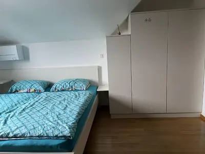 a bedroom with a bed and a white cabinet at Apartma Ajda 2 , Jezerska cesta 65, Kranj in Kranj