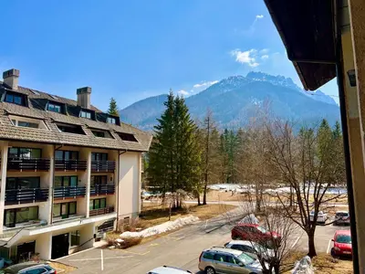 a view of a hotel with a parking lot and mountains at Studio Mila in Kranjska Gora