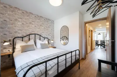 a bedroom with a brick wall and a bed at GrosAlp apartments in Lesce