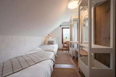 a bedroom with three beds and a desk and a window at GrosAlp apartments in Lesce
