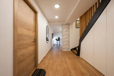 a hallway with a wooden door and a staircase at GrosAlp apartments in Lesce