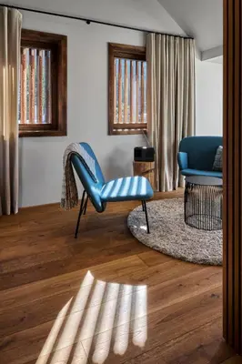 a living room with a blue chair and a couch at Milka Boutique Hotel in Kranjska Gora
