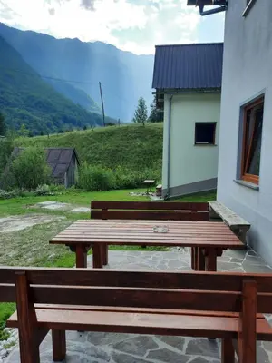 a wooden picnic bench sitting next to a building at Apartment Pretner, Lepena in Soča