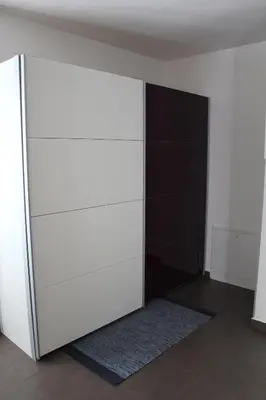 a closet with white shelves and a black door at Apartma V&T in Bovec