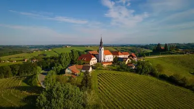 an aerial view of a house on a hill with a church at Hiša Pep's in Ivanjkovci