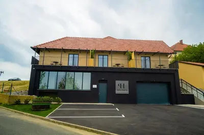 a building with a parking lot in front of it at Hiša Pep's in Ivanjkovci