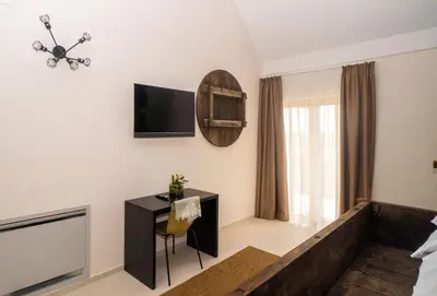 a bedroom with a desk and a tv on the wall at Hiša Pep's in Ivanjkovci