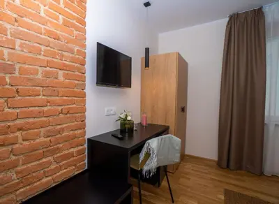 a room with a brick wall and a desk with a television at Hiša Pep's in Ivanjkovci