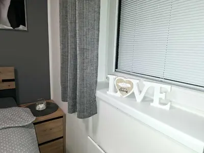 a bedroom with a window with a love sign on a window sill at Cherry House in Čatež ob Savi