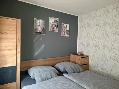 a bedroom with two beds and pictures on the wall at Cherry House in Čatež ob Savi