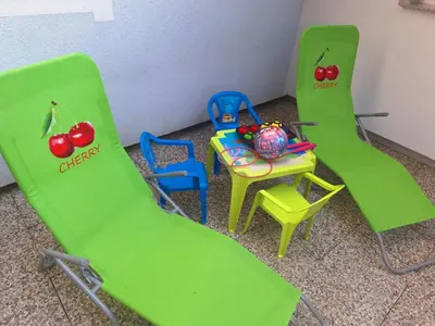 a group of green chairs and a table and a chair at Cherry House in Čatež ob Savi