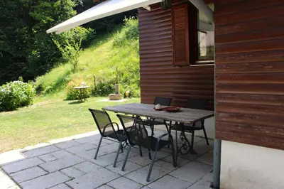 a wooden table and chairs on a patio at Panoramic Forest Chalet Bled Lake and Castle View in Bled