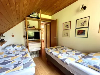 a bedroom with two beds and a book shelf at Panoramic Forest Chalet Bled Lake and Castle View in Bled